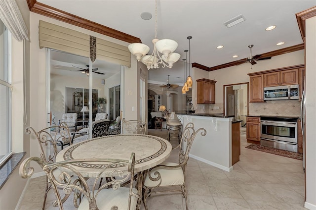 dining space with sink, an inviting chandelier, light tile patterned floors, and crown molding