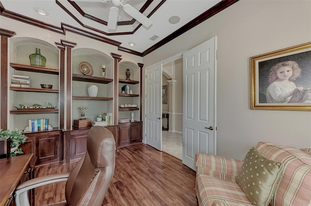 sitting room featuring built in shelves, wood-type flooring, ceiling fan, and crown molding