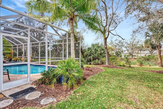 view of swimming pool with a lawn and a lanai