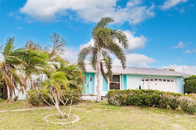 view of front of house with a front yard and a garage