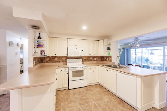 kitchen with kitchen peninsula, tasteful backsplash, sink, and white appliances