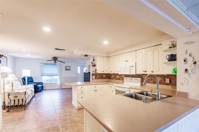 kitchen featuring sink, kitchen peninsula, ceiling fan, white appliances, and decorative backsplash