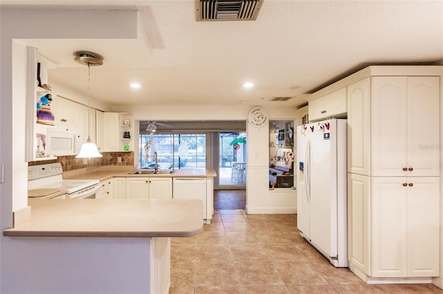 kitchen with white cabinets, white appliances, sink, and kitchen peninsula