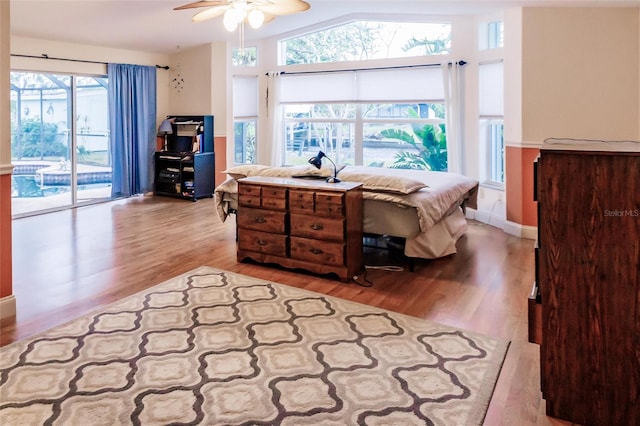 bedroom with light hardwood / wood-style floors, ceiling fan, lofted ceiling, and access to outside