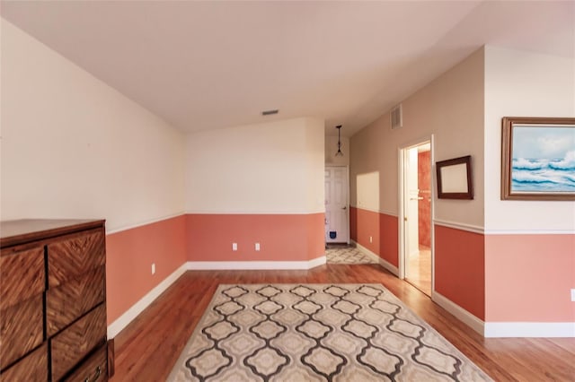 unfurnished room featuring light hardwood / wood-style flooring and lofted ceiling