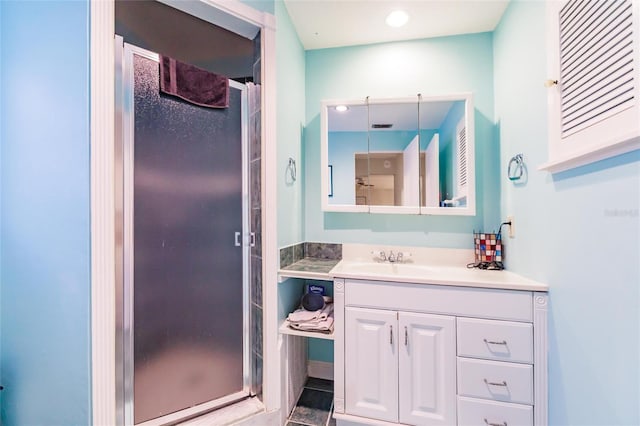 bathroom with walk in shower, vanity, and tile patterned floors