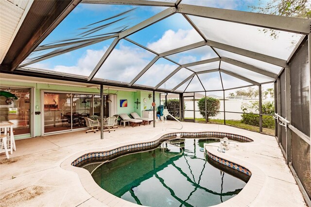 view of swimming pool featuring glass enclosure and a patio