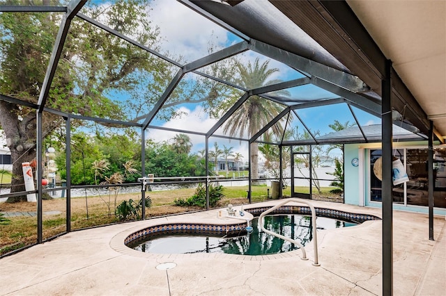 view of swimming pool featuring a hot tub, a patio, and a lanai