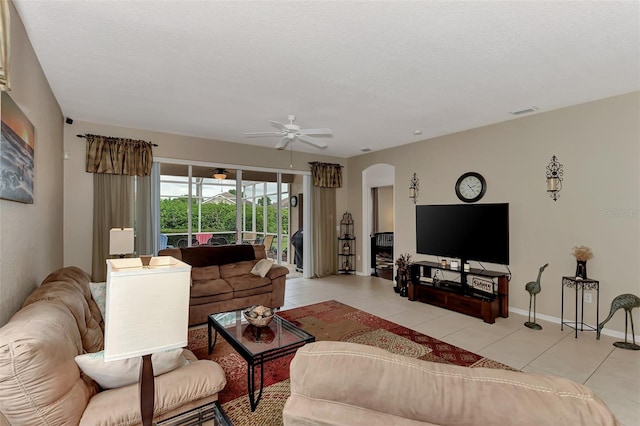 tiled living room featuring ceiling fan and a textured ceiling