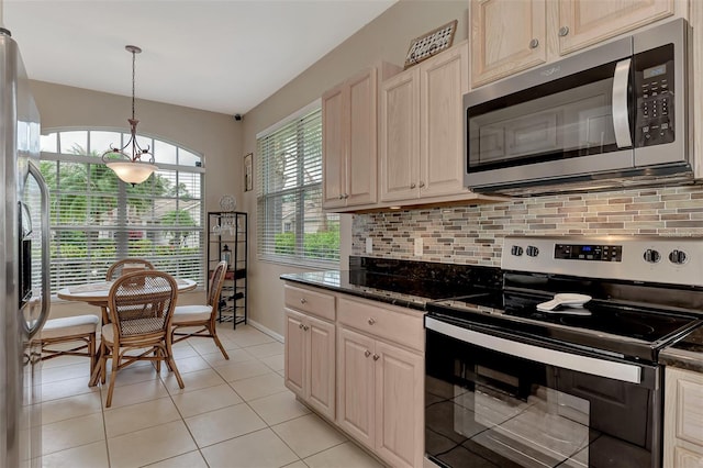 kitchen featuring tasteful backsplash, hanging light fixtures, light tile patterned flooring, and stainless steel appliances