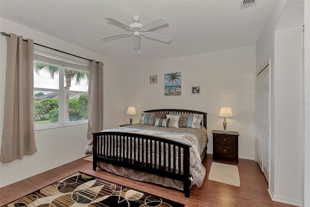 bedroom with wood-type flooring, ceiling fan, and a closet