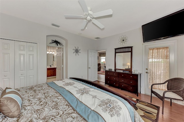 bedroom featuring a closet, multiple windows, hardwood / wood-style flooring, and ceiling fan