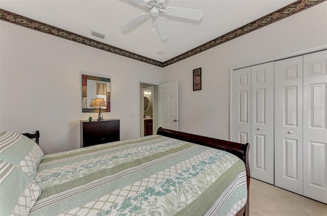 bedroom with light colored carpet, ceiling fan, and a closet