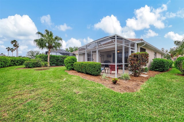 view of yard featuring glass enclosure and a patio area