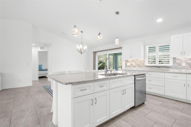 kitchen featuring white cabinetry, sink, a center island with sink, lofted ceiling, and pendant lighting