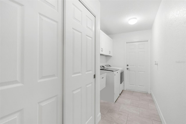 laundry area with washer and clothes dryer and cabinets