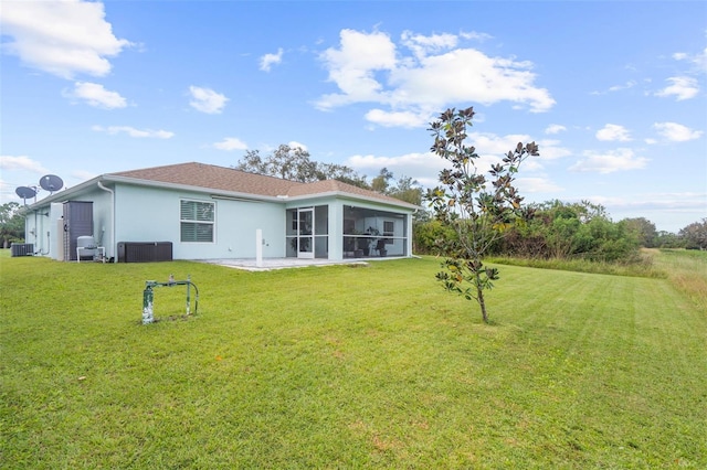 back of house featuring central AC, a sunroom, a lawn, and a patio area