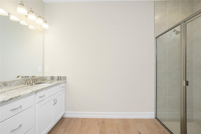 bathroom with vanity, hardwood / wood-style floors, and a shower with door