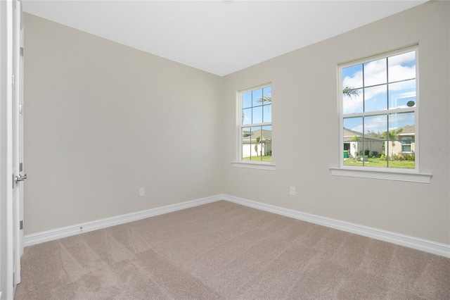 spare room featuring light carpet and a healthy amount of sunlight