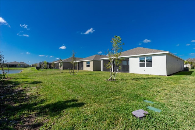 rear view of house with a lawn and a water view