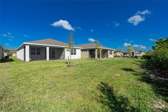 back of property featuring a sunroom and a yard