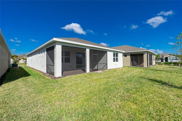 back of property with a sunroom and a lawn