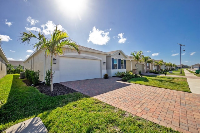 ranch-style house with a garage, a front yard, and central AC