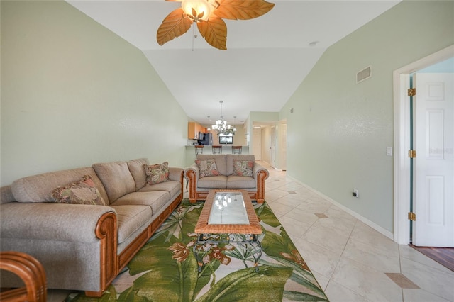 living room featuring ceiling fan with notable chandelier, light tile patterned floors, and vaulted ceiling