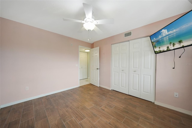 unfurnished bedroom featuring dark hardwood / wood-style floors, ceiling fan, and a closet