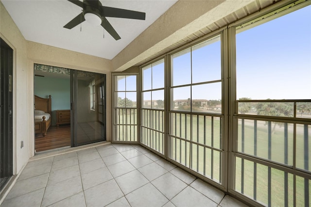 unfurnished sunroom featuring ceiling fan