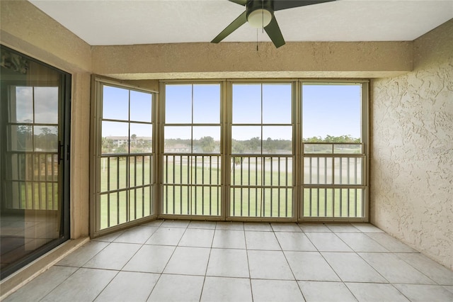 unfurnished sunroom with ceiling fan