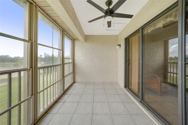 unfurnished sunroom with ceiling fan