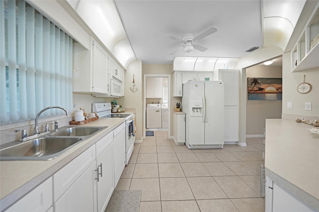 kitchen with sink, light tile patterned flooring, white cabinetry, white appliances, and washer and dryer