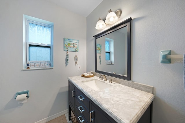 bathroom with tile patterned flooring, vanity, and a healthy amount of sunlight