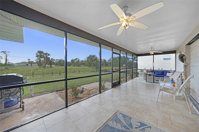 sunroom / solarium with a rural view and ceiling fan