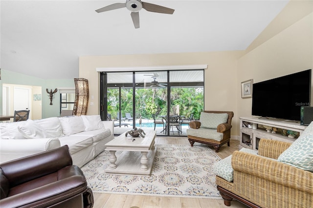 living room with lofted ceiling, ceiling fan, and light hardwood / wood-style flooring