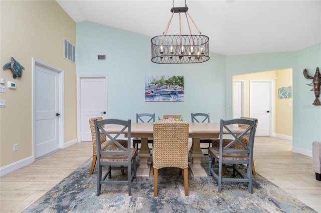 dining room featuring vaulted ceiling, a notable chandelier, and light hardwood / wood-style floors