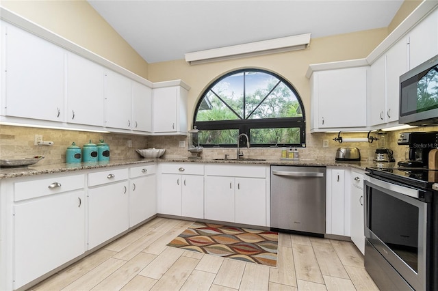 kitchen featuring white cabinets, appliances with stainless steel finishes, sink, and backsplash