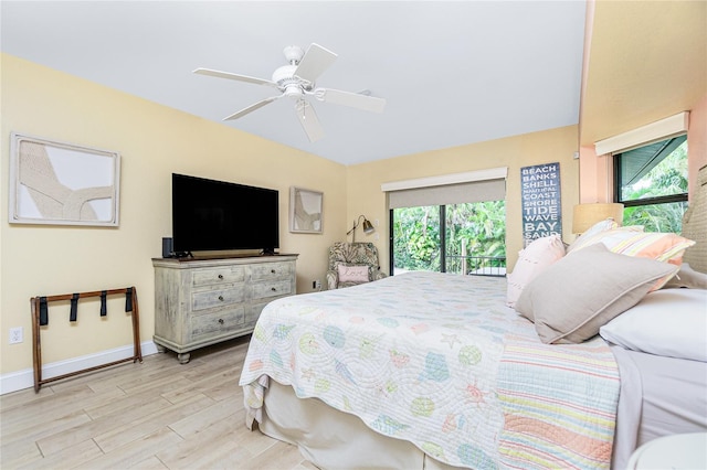 bedroom featuring access to outside, light hardwood / wood-style floors, multiple windows, and ceiling fan