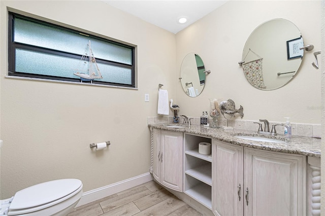 bathroom featuring toilet, vanity, and hardwood / wood-style flooring