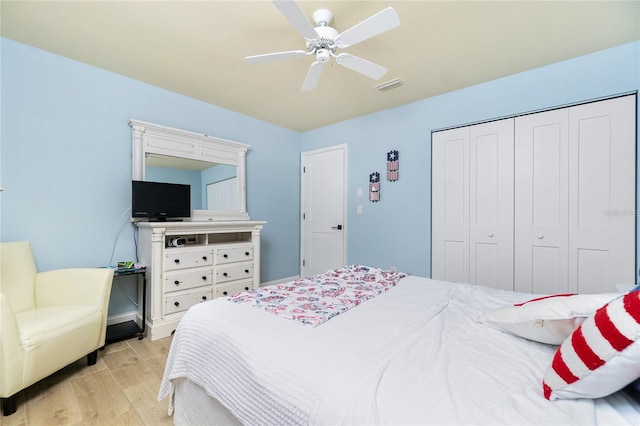 bedroom with ceiling fan, a closet, and light hardwood / wood-style flooring