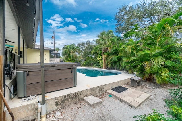 view of swimming pool featuring a hot tub and a patio area