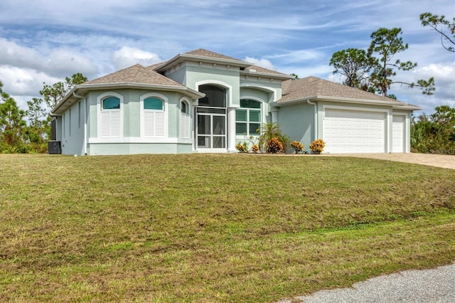 mediterranean / spanish home with a garage, central AC, and a front yard