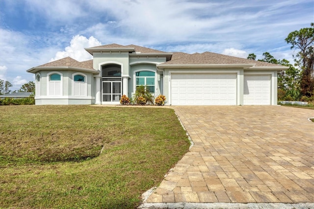 12194 Everglades Ave, Port Charlotte, FL 33981 - mediterranean / spanish-style house with an attached garage, decorative driveway, stucco siding, a front yard, and roof with shingles