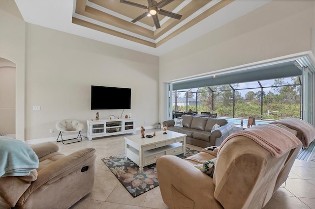 living room with ornamental molding, a high ceiling, light tile patterned floors, and ceiling fan