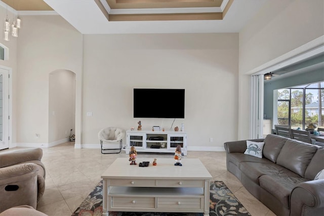 tiled living room with ornamental molding and a high ceiling