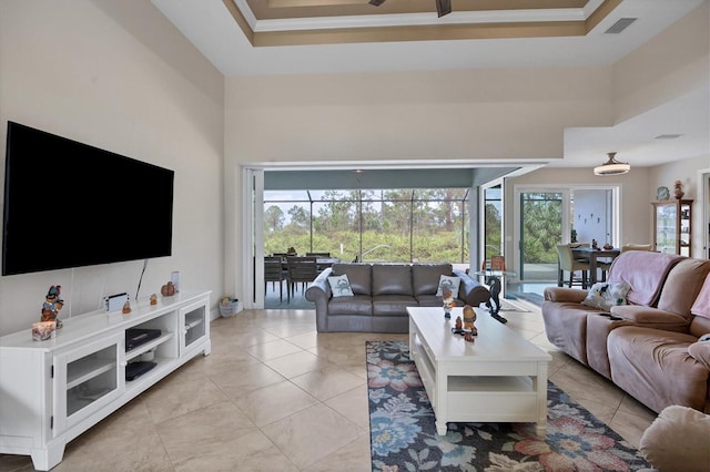 living room with a high ceiling, crown molding, and a tray ceiling