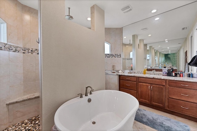 bathroom with tile patterned flooring, vanity, and plus walk in shower