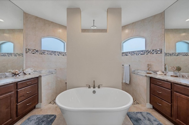 bathroom featuring a tub, plenty of natural light, and tile walls