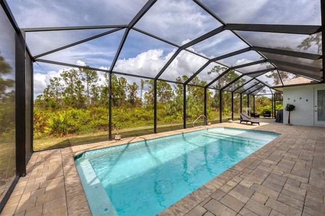 view of swimming pool featuring a patio and glass enclosure